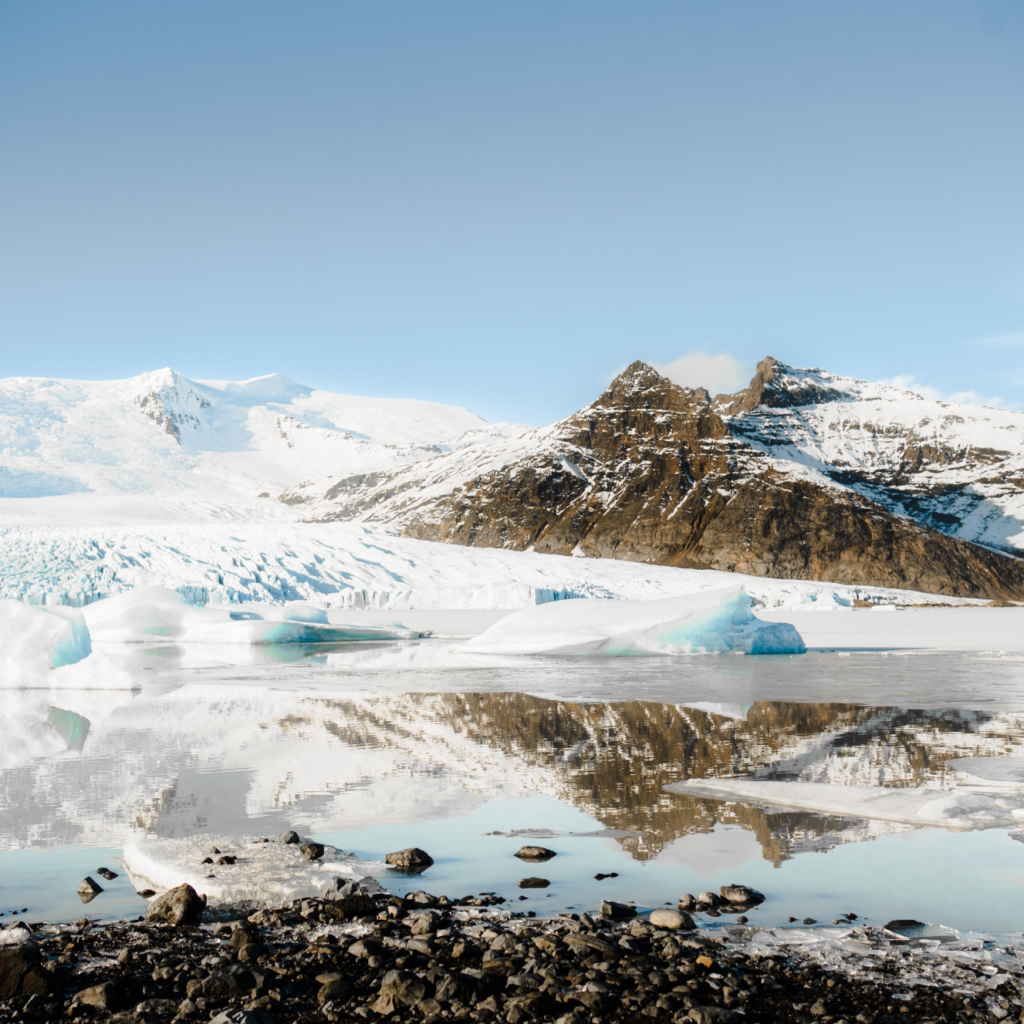 Reflection of a snow covered mountain and icy glacier at FJallsárlón Glacier Lagoon, Iceland